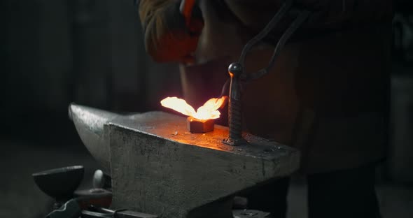 Blacksmith Forges the Red Hot Decorative Metal Product with Hammer on the Anvil Decorative Forging alt