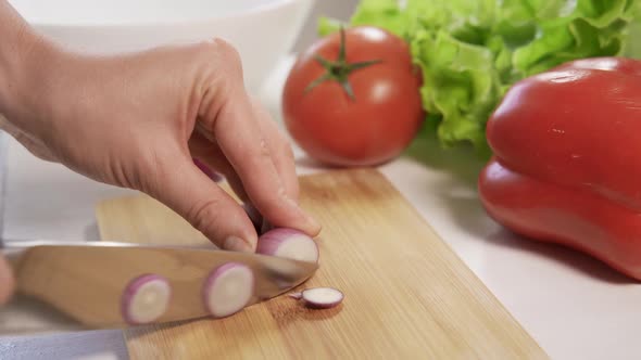 Woman Use a Kitchen Knife to Chop the Onions on a Cutting Board