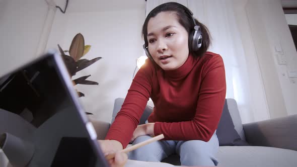 Businesswoman redshirt using a tablet with headphone for meeting online at home alt