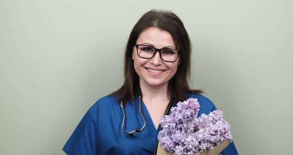 Doctor's Day, Celebration. Happy Smiling Female Medic with Bouquet of Flowers alt