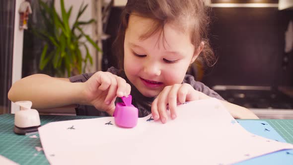 Little Girl Cutting Birds from Paper