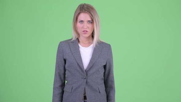 Angry Young Blonde Businesswoman Giving Thumbs Down alt