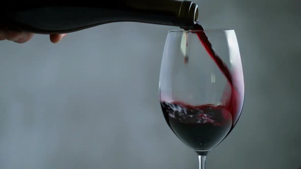 Red Wine Pouring Into Wine Glass. Close Up. alt