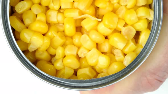 Hand Opens Metallic Tin Can of Marinated Sweet Corn alt