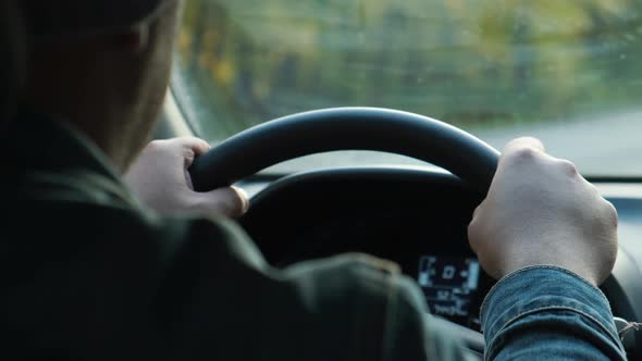 Male Hands on the Steering Wheel alt