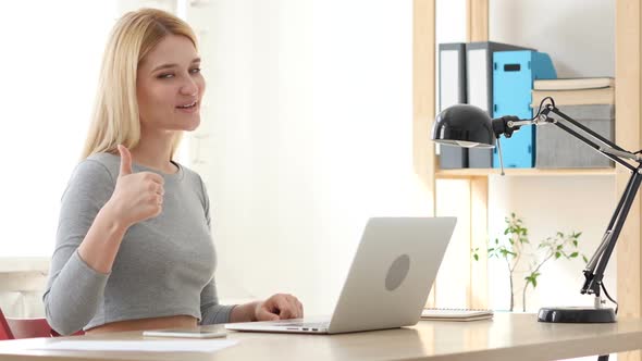 Thumbs Up, Woman Gesturing while Sitting in Office alt