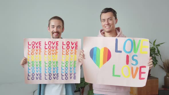 Two Young Handsome Guys Let Down Lgbt Posters Look at Each Other and Smile alt