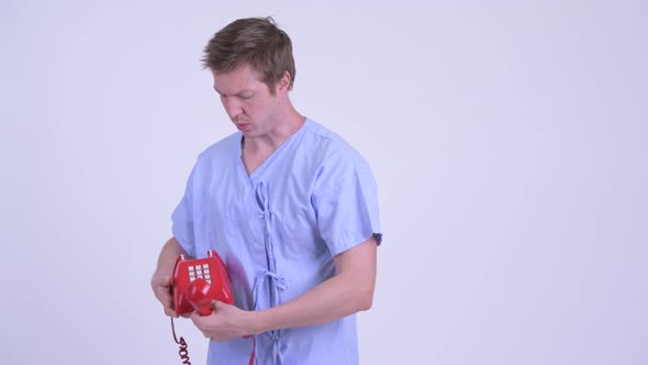 Young Man Patient Talking on Old Telephone and Getting Angry alt