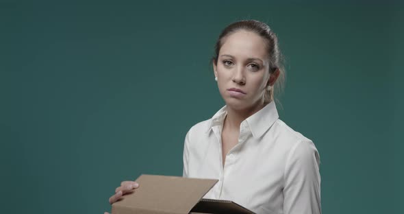 Disappointed woman looking into a cardboard box, she has received the wrong delivery