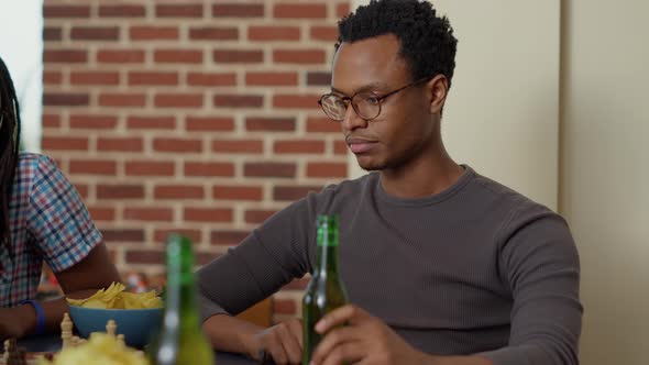 African American Man Playing Chess Match with Friends alt