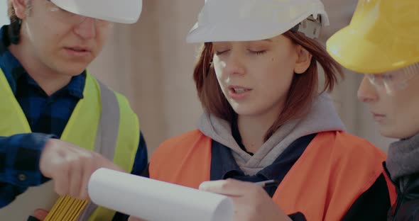 Female Construction Worker Discussing with Coworker and Contractor alt