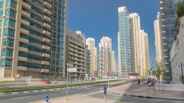 Dubai Marina with Skyscrapers Timelapse and Traffic on the Street Near Concrete Road Bridge Through alt