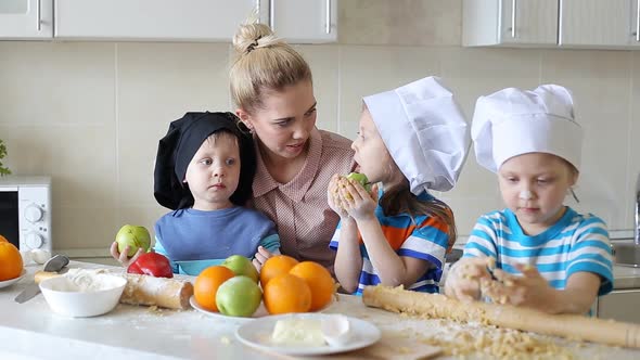 Little Chefs Learn To Cook. Mother with Children in the Kitchen