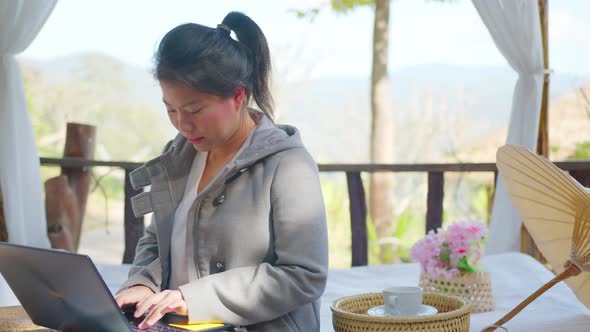 asian female woman freelance career sit relax in gazebo working with laptop