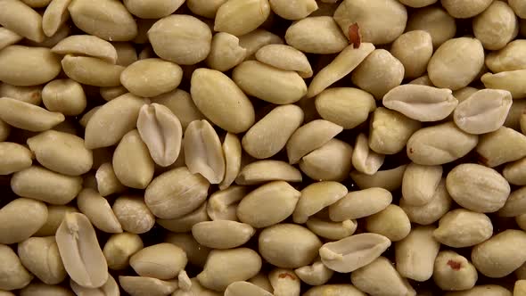 Falling blanched peanuts on a black background. alt