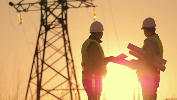 Silhouette of Engineers Looks at the Construction of Highvoltage Power alt