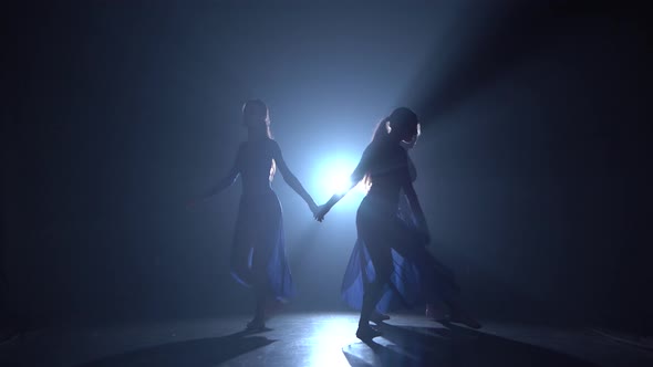 Silhouettes of Professional Ballerinas Dancing Elements of Modern Ballet alt