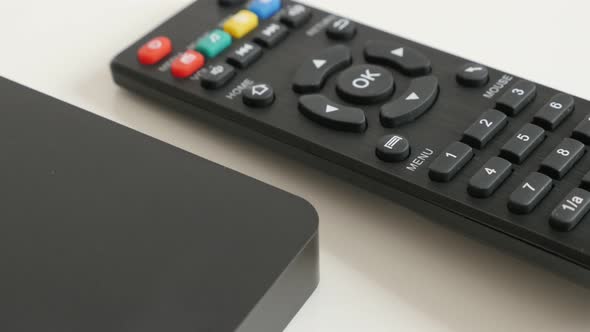 Remote control and shiny black multimedia player on white background 4K 2160p 30fps UltraHD video -  alt