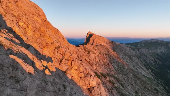 Dolomites mountains peaks with a hiking path on a summer sunrise alt