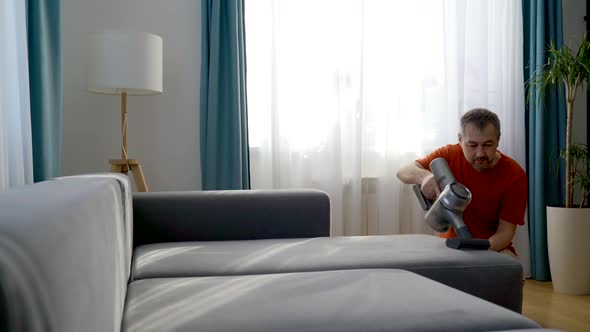 A Man Using a Vacuum Cleaner at Home alt