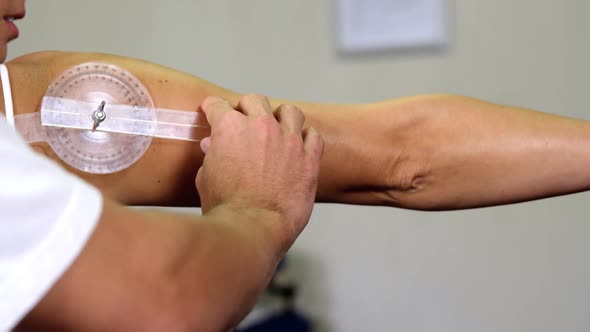 Male therapist measuring female patient's back with medical ruler alt