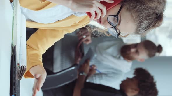Vertical Screen Woman Working in Office and Talking on Phone alt
