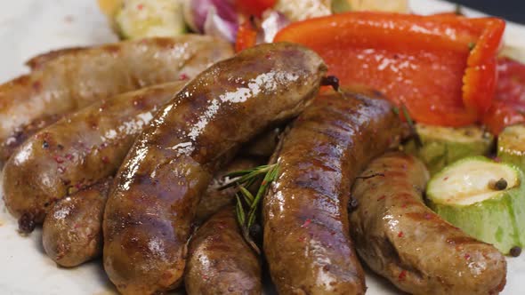 Portion of Grilled Sausages on Pita Bread with Baked Zucchini Tomatoes Garlic Paprika