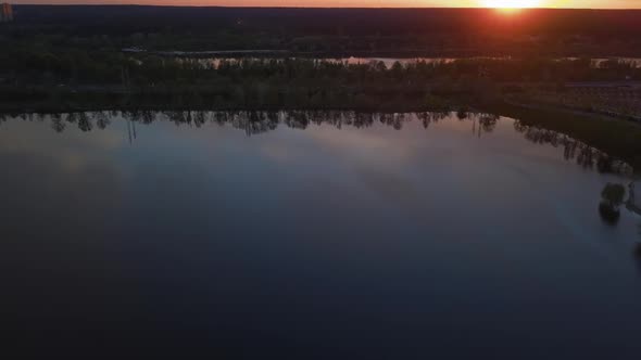 Colorful Sunset Over the Road with Cars Overlooking the Forest and Lake Ukraine Kiev on May 6 2021