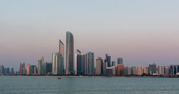 Abu Dhabi City Skyline with Skyscrapers Before Sunset with Water Reflection Day to Night Transition