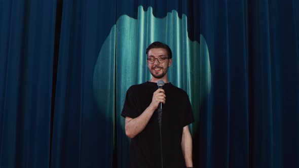 Comedian Performing Standup Monologue on Stage of Small Venue