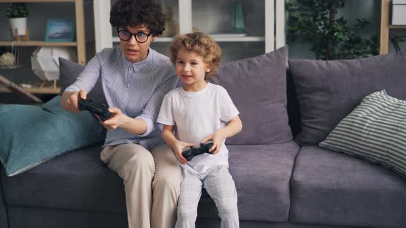 Happy Child Playing Video Games with Mother at Home Then Jumping Having Fun alt