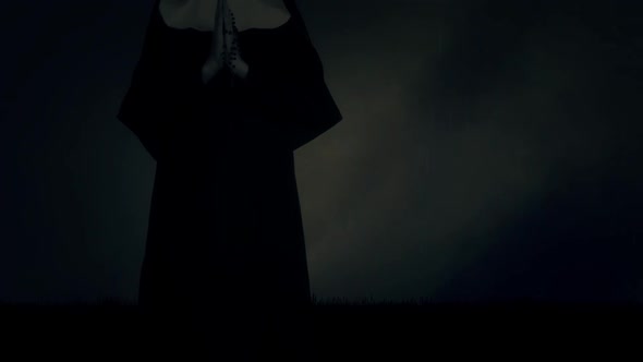 Nun Standing In A Praying Pose Under Rain And Thunderstorm alt