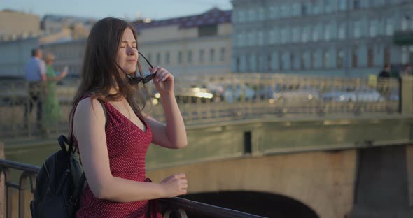 Portrait of a Young Beautiful Girl in the City in the Setting Sun alt