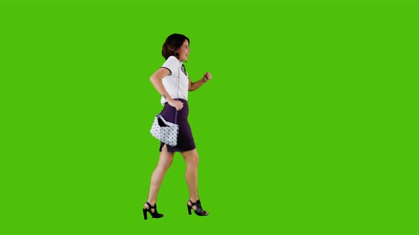Stylish Happy Woman Walking and Dancing Over a Green Screen in A Full Body Shot alt