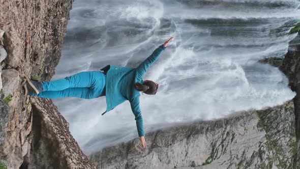 Woman Standing By Waterfall with Hands Raised alt