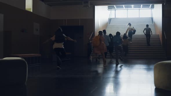 Group Pupils Running Out Classroom Heading Staircase alt