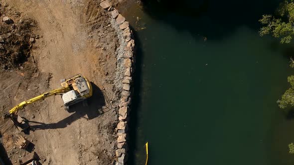 Earthing equipment repairing a section of river damaged by a flood caused by a tropical cyclone alt