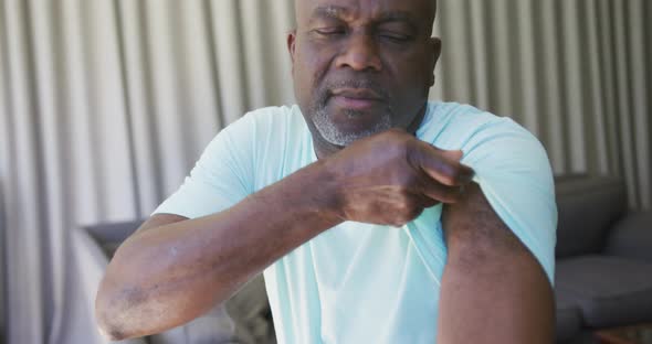 African american man showing plaster on arm where he was vaccinated against coronavirus alt