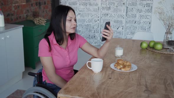 Young Woman in Wheelchair Talking with Friends Using Internet Ca alt