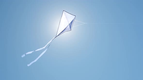 Blue kite soars in the blue sky.