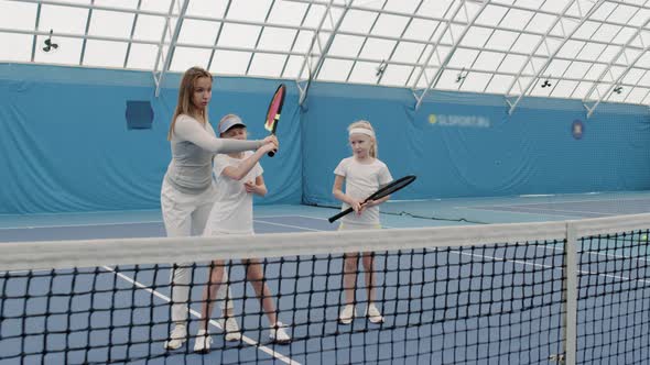 Girls Having Tennis Training With Coach Indoors alt