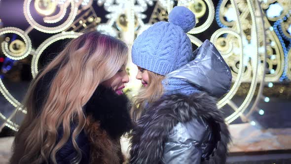 Beautiful Mother Touching Her Little Girl on Illuminated Night City Street alt