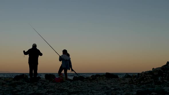 Two People Fishermen a Man and a Woman Fishing at Sunset alt