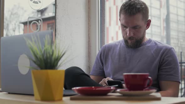 Bearded Man Surfing the Phone