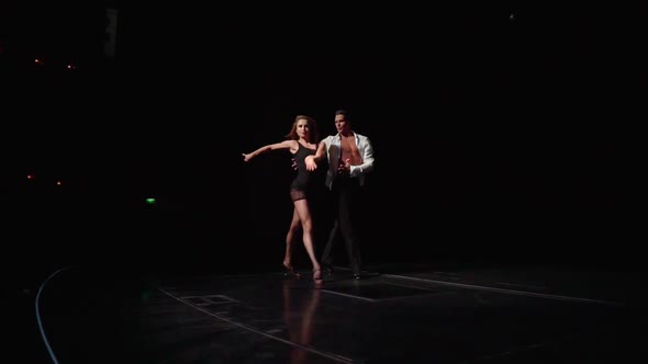 Two Ballroom Dancers Coming Out of Darkness Onto Floodlit Stage with Flexible Stepshand Swingship