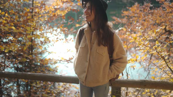 Happy Young Woman Traveler in Casual Wear and Backpack Against Mountain Lake Sinevir in National alt