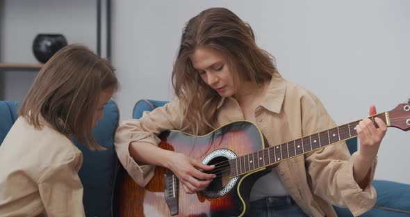 Family Weekend Mother and Little Daughter are Playing Guitar and Singing Songs Woman is Teaching