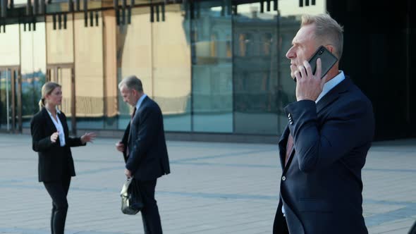 Businessman Making Phone Call, Business Phone Sales, Colleagues in the Background