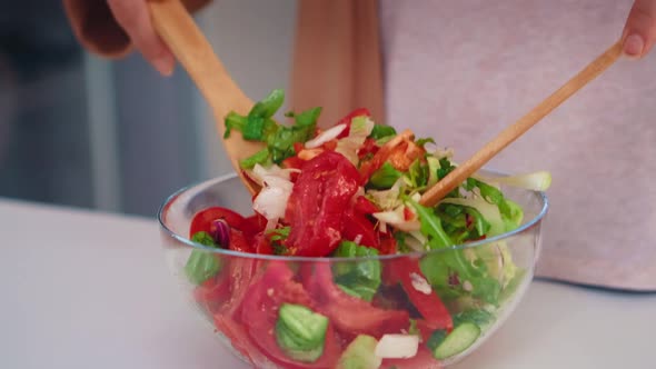 Mixing Salad with Wooden Spoons alt