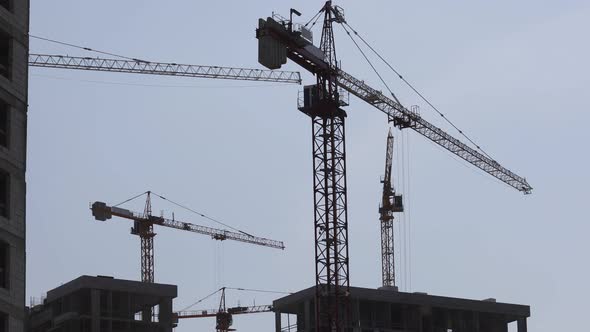 Construction Cranes Against The Blue Sky